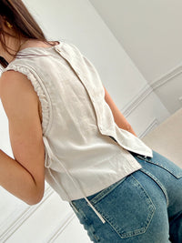 Ce top beige pour femme Tibo, sans manches avec volants, est idéal pour les jours ensoleillés. Les liens de serrage aux épaules ajoutent une touche de charme, tandis que les boutons au dos sur la longueur et le col rond offrent un look élégant et facile à porter.&nbsp;