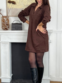 Adoptez un style élégant et confortable avec cette robe marron effet daim. Sa coupe ample offre une liberté de mouvement idéale, tandis que le col chemise en V et les boutons aux poignets ajoutent une touche raffinée.