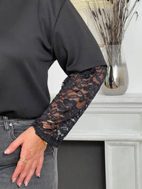 Tee-shirt noir pour femme au design élégant et facile à porter, parfait pour toutes les occasions. Il présente un col rond classique et des manches en dentelles qui ajoutent une touche raffinée et féminine. Ce tee-shirt noir polyvalent se marie facilement avec différents styles pour un look chic et intemporel.