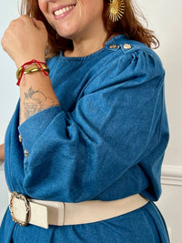 Robe en jean grande taille femme au style casual chic. Col rond et coupe droite moderne, idéale au quotidien comme en sortie. Détails raffinés : boutons dorés aux poignets et à l’épaule. Bleu intemporel, 100% coton pour allier confort et élégance.
