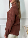 Cette chemise marron, avec ses manches longues et son col classique, est un indispensable du dressing ! Dotée de boutons tout le long et aux poignets, elle se démarque par sa coupe fluide et ses manches retroussables pour un style modulable selon l’occasion. Parfaite pour un look casual chic ou une allure plus habillée, elle s'associe aisément à un jean, un pantalon tailleur, ou même une jupe pour un look élégant et décontracté.