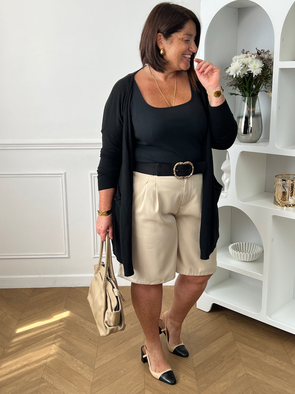 Bermuda beige grande taille pour femme, alliant confort et style pour la saison estivale. Équipé de deux poches latérales pratiques, d’une taille élastique au dos et de passants pour ceinture, il assure un ajustement parfait. Sa fermeture avec bouton et zip garantit un bon maintien. Polyvalent et facile à assortir, ce bermuda taupe est un indispensable du dressing casual chic.