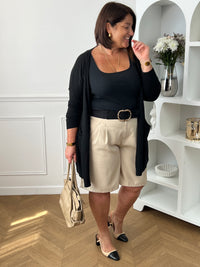 Bermuda beige grande taille pour femme, alliant confort et style pour la saison estivale. Équipé de deux poches latérales pratiques, d’une taille élastique au dos et de passants pour ceinture, il assure un ajustement parfait. Sa fermeture avec bouton et zip garantit un bon maintien. Polyvalent et facile à assortir, ce bermuda taupe est un indispensable du dressing casual chic.