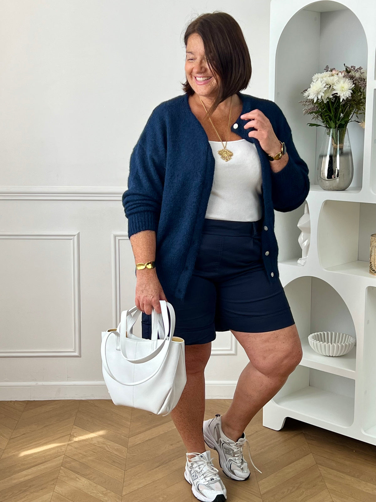 Découvrez le confort et le style avec le bermuda grande taille Charlize. Fait en tissu bleu foncé, il est doté de 2 poches latérales pratiques, d'une taille élastique et de passants pour ceinture