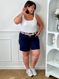 Découvrez le confort et le style avec le bermuda grande taille Charlize. Fait en tissu bleu foncé, il est doté de 2 poches latérales pratiques, d'une taille élastique et de passants pour ceinture