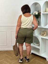 Découvrez le confort et le style avec le bermuda grande taille Charlize. Fait en tissu kaki, il est doté de 2 poches latérales pratiques, d'une taille élastique et de passants pour ceinture
