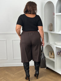 Dos pantalon marron chocolat grande taille coupe culotte ample – taille élastiquée curve – porté avec top noir et bottes – Loïcia