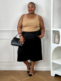 Bermuda noir grande taille femme porté avec un débardeur beige pour un look chic et tendance.