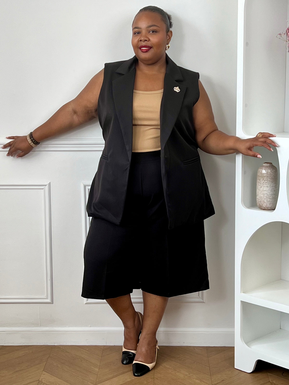 Bermuda noir fluide grande taille associé à un gilet sans manches pour une tenue élégante.