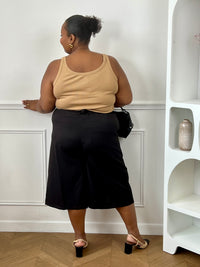 Bermuda noir grande taille femme porté avec un top marron pour un look décontracté et moderne.
