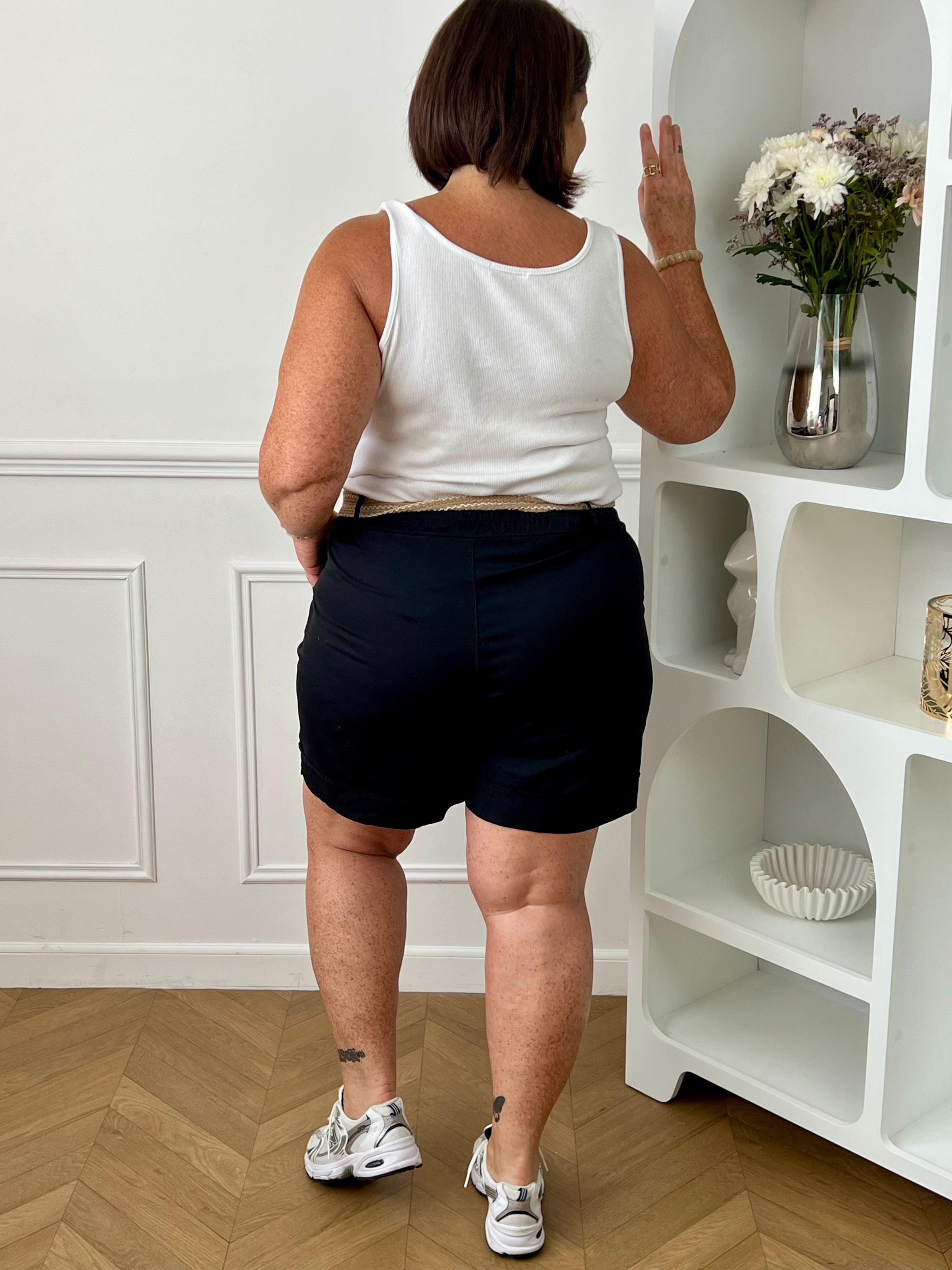 Découvrez le confort et le style avec le bermuda grande taille Charlize. Fait en tissu noir, il est doté de 2 poches latérales pratiques, d'une taille élastique et de passants pour ceinture