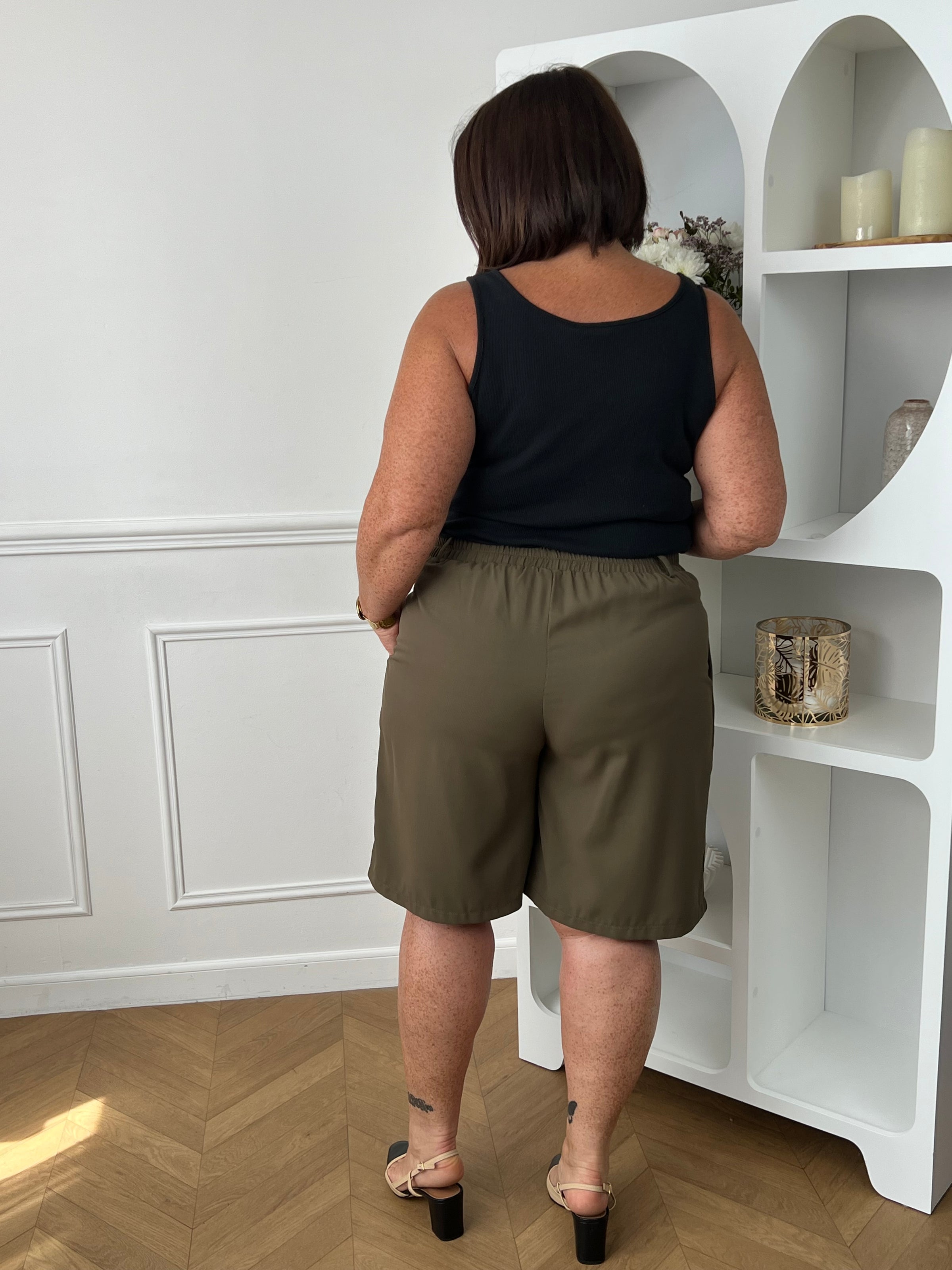 Bermuda taupe grande taille pour femme, alliant confort et style pour la saison estivale. Équipé de deux poches latérales pratiques, d’une taille élastique au dos et de passants pour ceinture, il assure un ajustement parfait. Sa fermeture avec bouton et zip garantit un bon maintien. Polyvalent et facile à assortir, ce bermuda taupe est un indispensable du dressing casual chic.