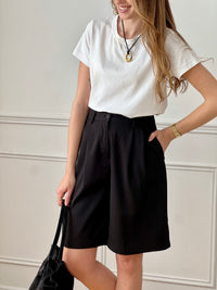 Bermuda noir femme, un basique incontournable pour un look à la fois chic et décontracté. Doté de deux poches latérales et de deux poches factices à l’arrière, il allie style et praticité. Ses passants pour ceinture, ainsi que sa fermeture par bouton et zip, assurent un maintien parfait. Facile à associer, ce bermuda noir s’adapte à toutes vos tenues du quotidien.