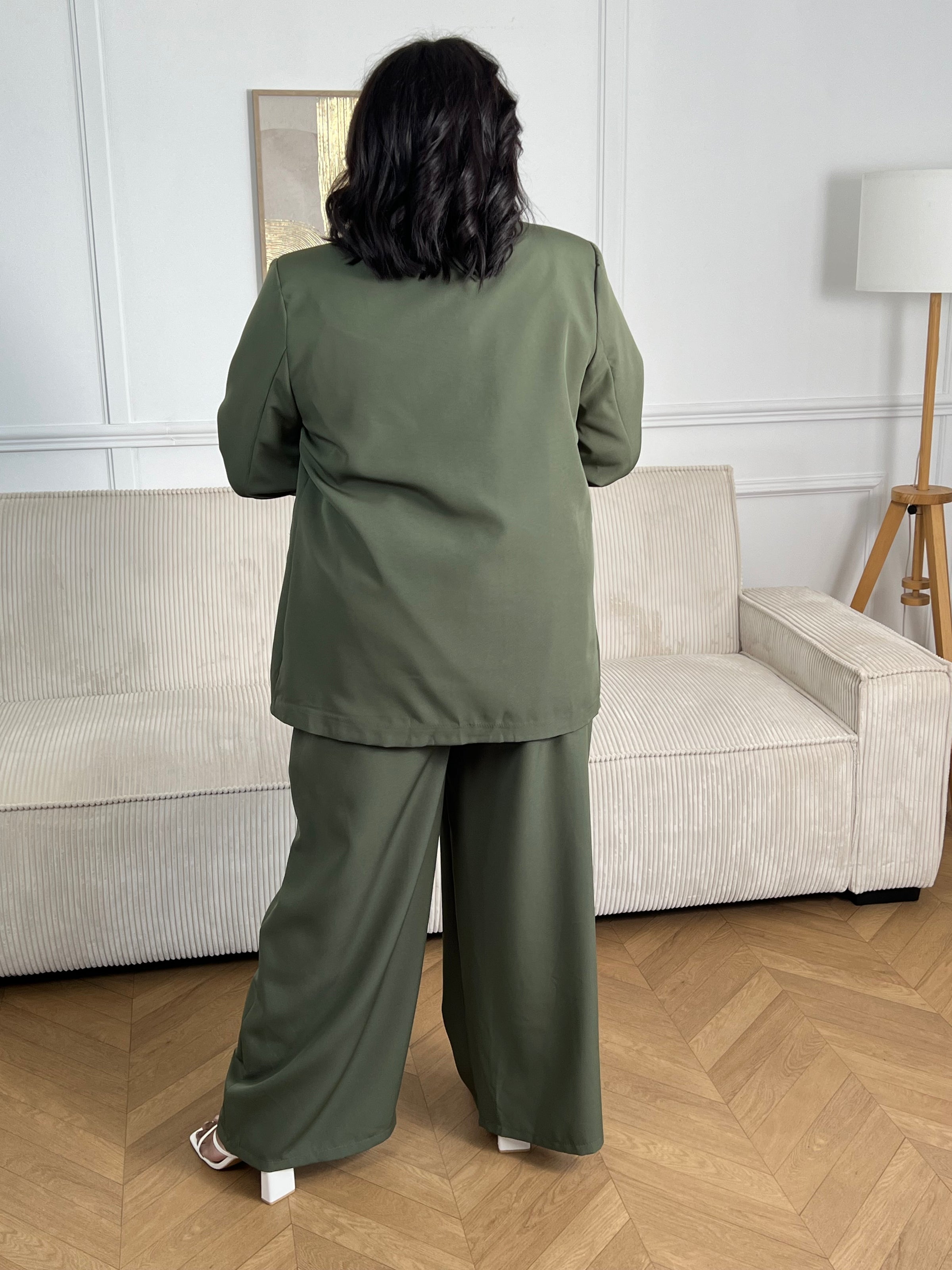 Blazer kaki grande taille Paola, conçu pour affirmer votre style avec élégance. Manches longues agrémentées de motifs fleuris aux poignets pour une touche de féminité. Épaulettes structurantes et doublure intérieure pour un confort optimal. Deux poches factices sur le devant complètent ce design intemporel. Parfait pour sublimer vos tenues professionnelles ou occasionnelles.