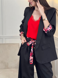 Blazer noir Paola, conçu pour affirmer votre style avec élégance. Manches longues agrémentées de motifs fleuris aux poignets pour une touche de féminité. Épaulettes structurantes et doublure intérieure pour un confort optimal. Deux poches factices sur le devant complètent ce design intemporel. Parfait pour sublimer vos tenues professionnelles ou occasionnelles.