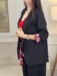 Blazer noir Paola, conçu pour affirmer votre style avec élégance. Manches longues agrémentées de motifs fleuris aux poignets pour une touche de féminité. Épaulettes structurantes et doublure intérieure pour un confort optimal. Deux poches factices sur le devant complètent ce design intemporel. Parfait pour sublimer vos tenues professionnelles ou occasionnelles.