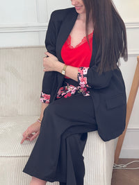 Blazer noir Paola, conçu pour affirmer votre style avec élégance. Manches longues agrémentées de motifs fleuris aux poignets pour une touche de féminité. Épaulettes structurantes et doublure intérieure pour un confort optimal. Deux poches factices sur le devant complètent ce design intemporel. Parfait pour sublimer vos tenues professionnelles ou occasionnelles.
