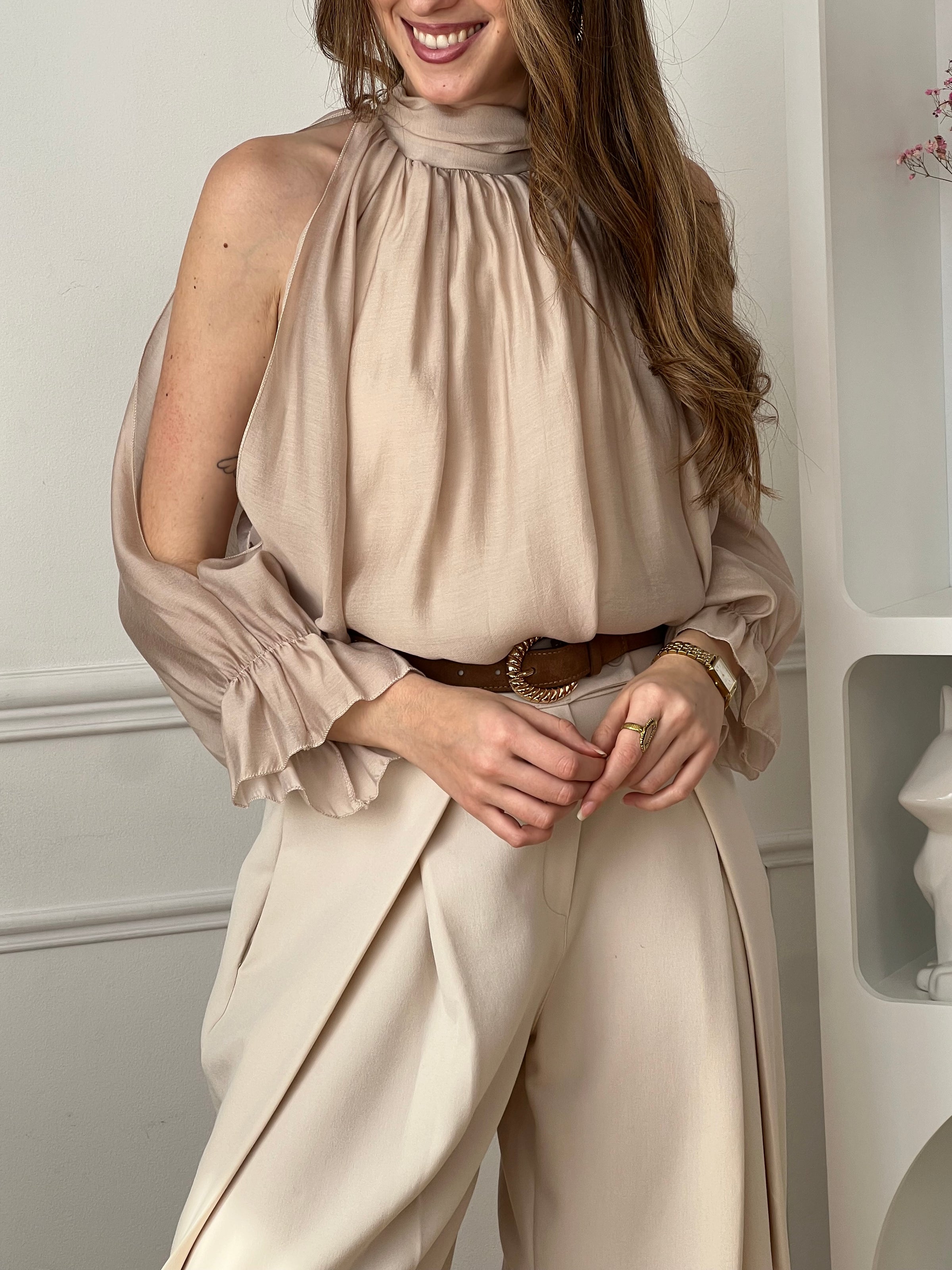 Blouse fluide beige à manches longues, idéale pour une allure élégante et moderne. Son col montant et ses ouvertures au niveau des bras apportent une touche originale et féminine. Dotée d’une ouverture au dos avec bouton et d’une doublure (sauf aux manches), elle offre confort et légèreté. Facile à porter, cette chemise beige s’adapte parfaitement à un look chic du quotidien.
