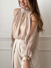 Blouse fluide beige à manches longues, idéale pour une allure élégante et moderne. Son col montant et ses ouvertures au niveau des bras apportent une touche originale et féminine. Dotée d’une ouverture au dos avec bouton et d’une doublure (sauf aux manches), elle offre confort et légèreté. Facile à porter, cette chemise beige s’adapte parfaitement à un look chic du quotidien.
