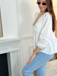 Blouse blanche pour femme, élégante et intemporelle, idéale pour toutes les occasions.
Dotée de manches longues, d’un col V et de délicates broderies sur le devant et les manches.
Ses détails avec boutons factices, lien et poignets élastiques apportent une touche raffinée.
Confectionnée en 100 % coton, elle offre confort et légèreté au quotidien.