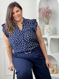 Blouse à motifs grande taille femme, idéale pour une tenue légère et féminine. Sans manches, avec un col V et des volants aux épaules, elle apporte une touche élégante et tendance. Ses motifs pois bleu et écru ajoutent du charme et du style à vos looks. Facile à porter, cette blouse est parfaite pour un look estival chic et décontracté.