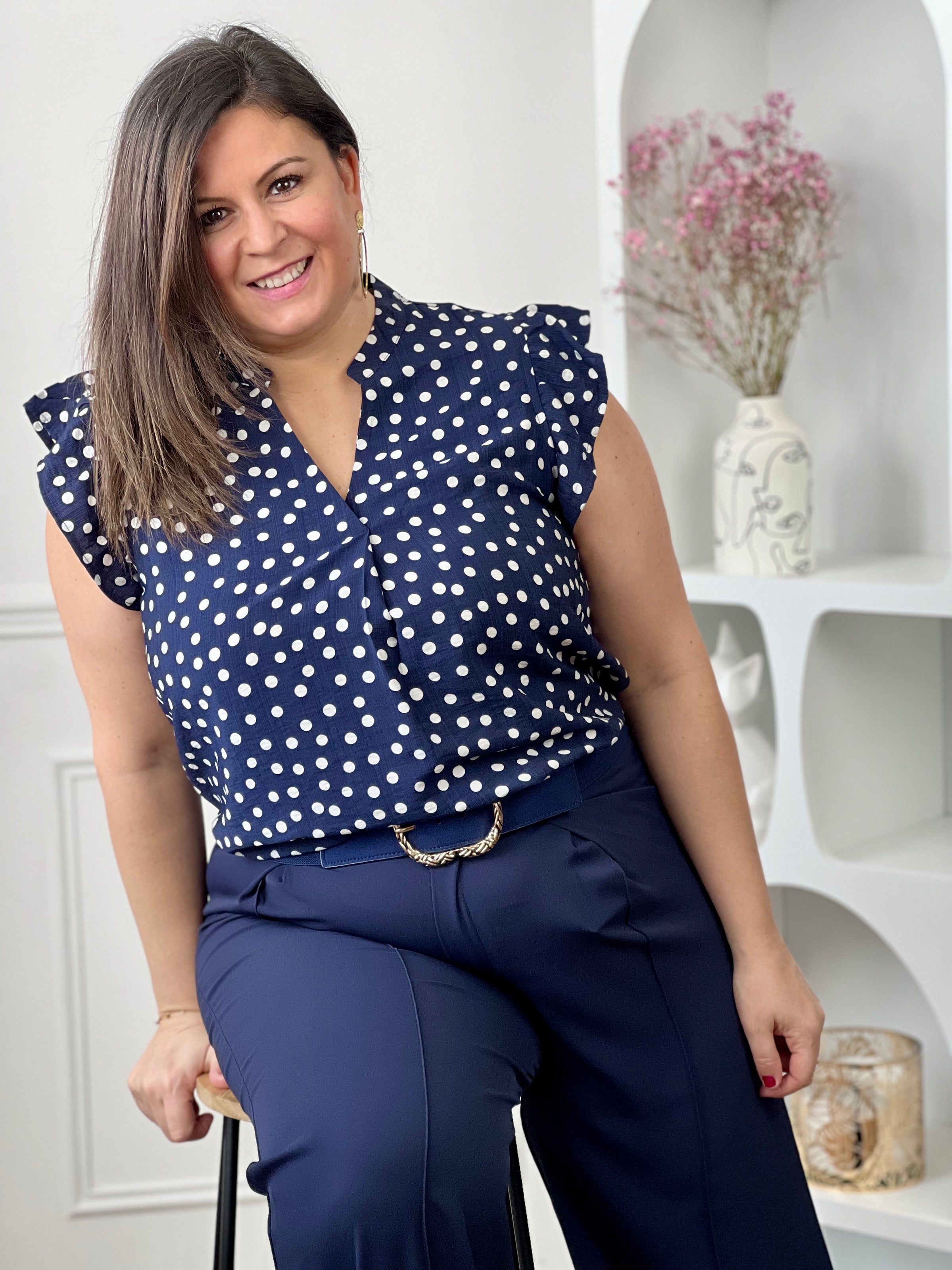 Blouse à motifs grande taille femme, idéale pour une tenue légère et féminine. Sans manches, avec un col V et des volants aux épaules, elle apporte une touche élégante et tendance. Ses motifs pois bleu et écru ajoutent du charme et du style à vos looks. Facile à porter, cette blouse est parfaite pour un look estival chic et décontracté.