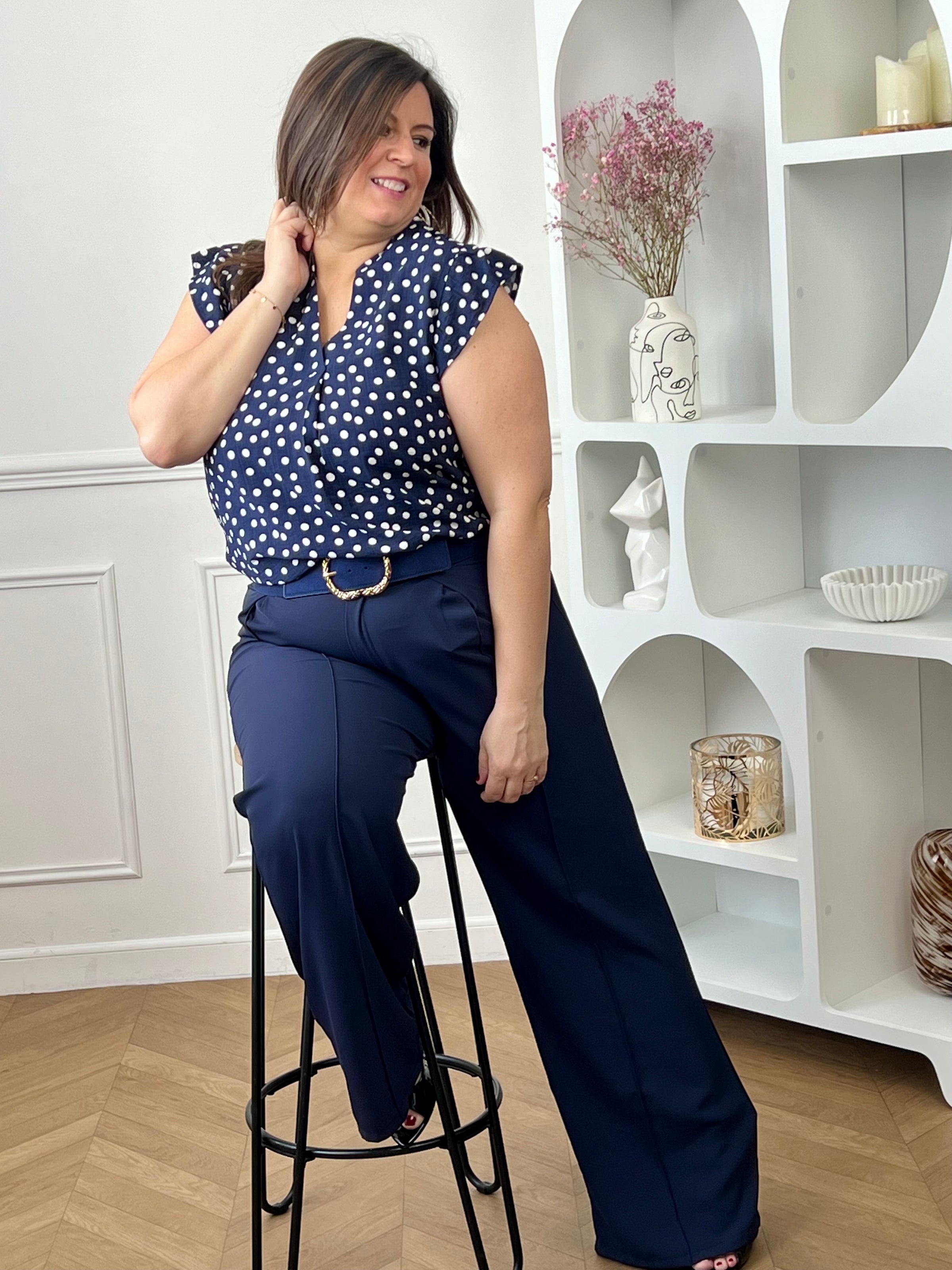 Blouse à motifs grande taille femme, idéale pour une tenue légère et féminine. Sans manches, avec un col V et des volants aux épaules, elle apporte une touche élégante et tendance. Ses motifs pois bleu et écru ajoutent du charme et du style à vos looks. Facile à porter, cette blouse est parfaite pour un look estival chic et décontracté.