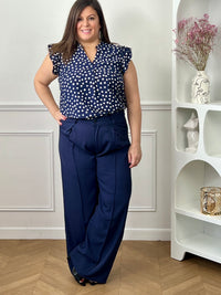Blouse à motifs grande taille femme, idéale pour une tenue légère et féminine. Sans manches, avec un col V et des volants aux épaules, elle apporte une touche élégante et tendance. Ses motifs pois bleu et écru ajoutent du charme et du style à vos looks. Facile à porter, cette blouse est parfaite pour un look estival chic et décontracté.