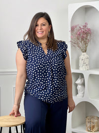 Blouse à motifs grande taille femme, idéale pour une tenue légère et féminine. Sans manches, avec un col V et des volants aux épaules, elle apporte une touche élégante et tendance. Ses motifs pois bleu et écru ajoutent du charme et du style à vos looks. Facile à porter, cette blouse est parfaite pour un look estival chic et décontracté.