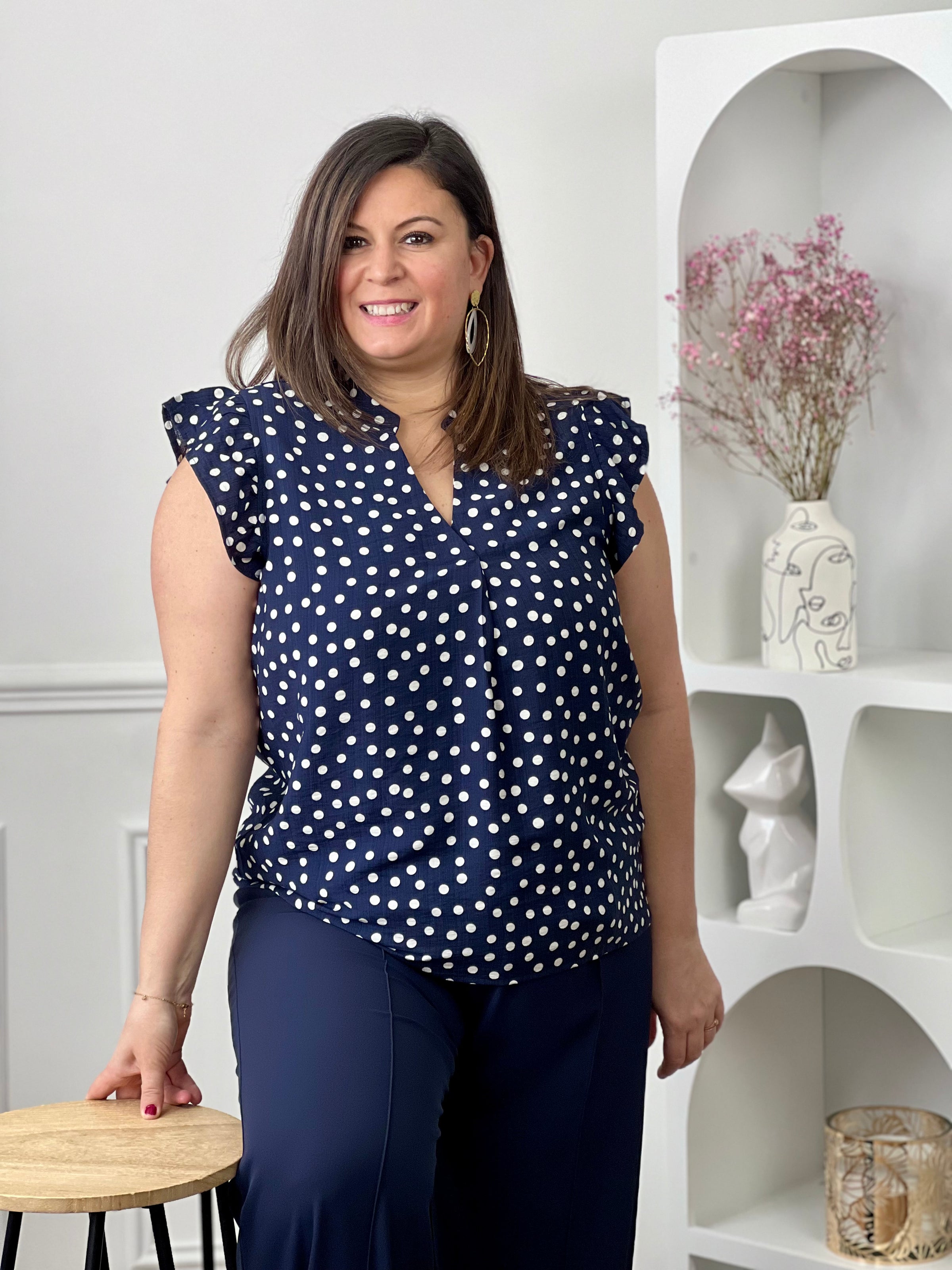 Blouse à motifs grande taille femme, idéale pour une tenue légère et féminine. Sans manches, avec un col V et des volants aux épaules, elle apporte une touche élégante et tendance. Ses motifs pois bleu et écru ajoutent du charme et du style à vos looks. Facile à porter, cette blouse est parfaite pour un look estival chic et décontracté.