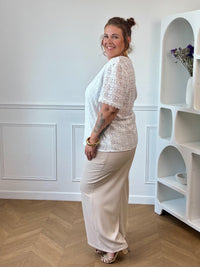 Apportez une touche de douceur et d'élégance à votre dressing avec cette blouse écrue grande taille femme. Son col V et ses manches courtes offrent une coupe féminine et confortable, idéale pour la belle saison. Délicatement brodée, elle se distingue par son dos ajouré qui apporte une note raffinée et tendance. Doublée sur le devant pour plus de confort, cette blouse écrue est parfaite pour composer des tenues chic et légères au quotidien.