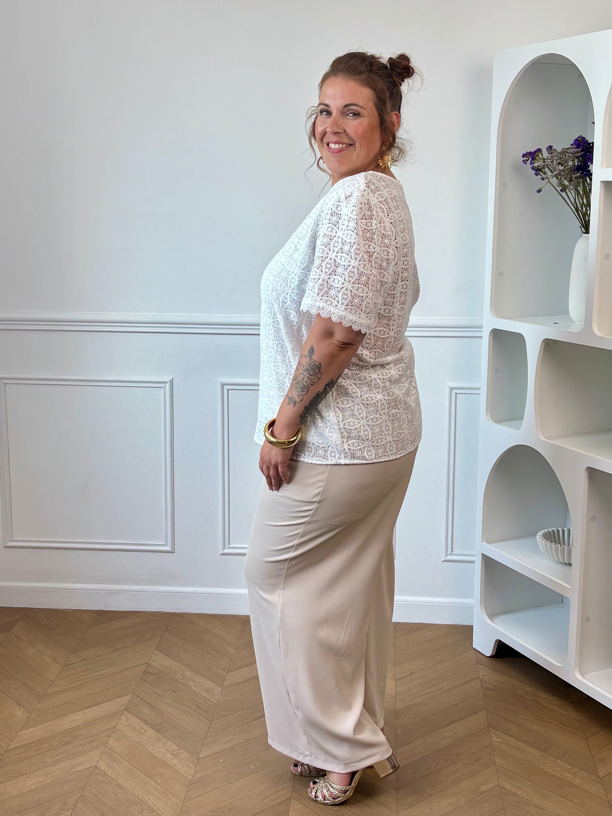 Apportez une touche de douceur et d'élégance à votre dressing avec cette blouse écrue grande taille femme. Son col V et ses manches courtes offrent une coupe féminine et confortable, idéale pour la belle saison. Délicatement brodée, elle se distingue par son dos ajouré qui apporte une note raffinée et tendance. Doublée sur le devant pour plus de confort, cette blouse écrue est parfaite pour composer des tenues chic et légères au quotidien.