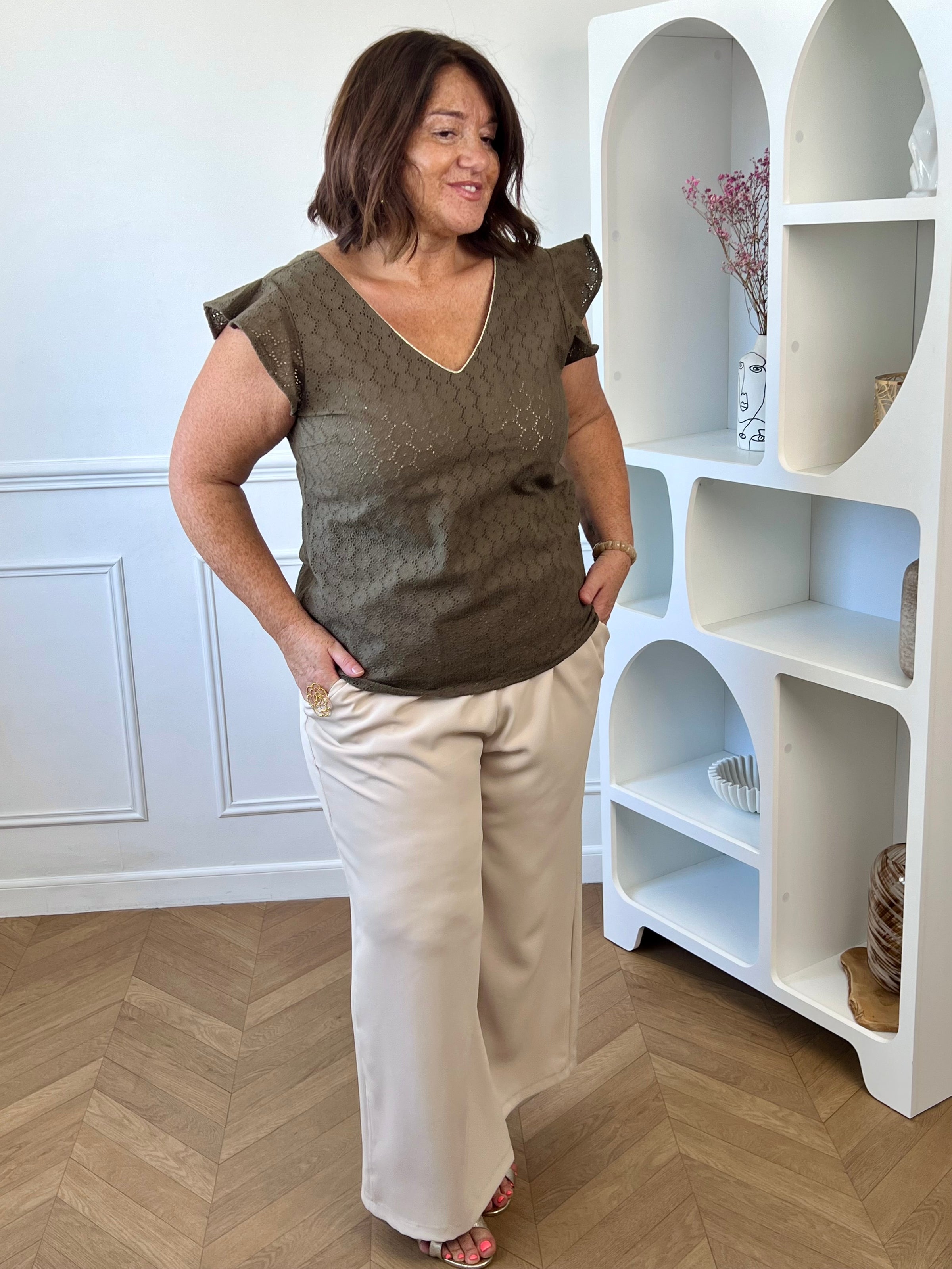 Blouse en coton avec col V au dos, lien de serrage et petits boutons.