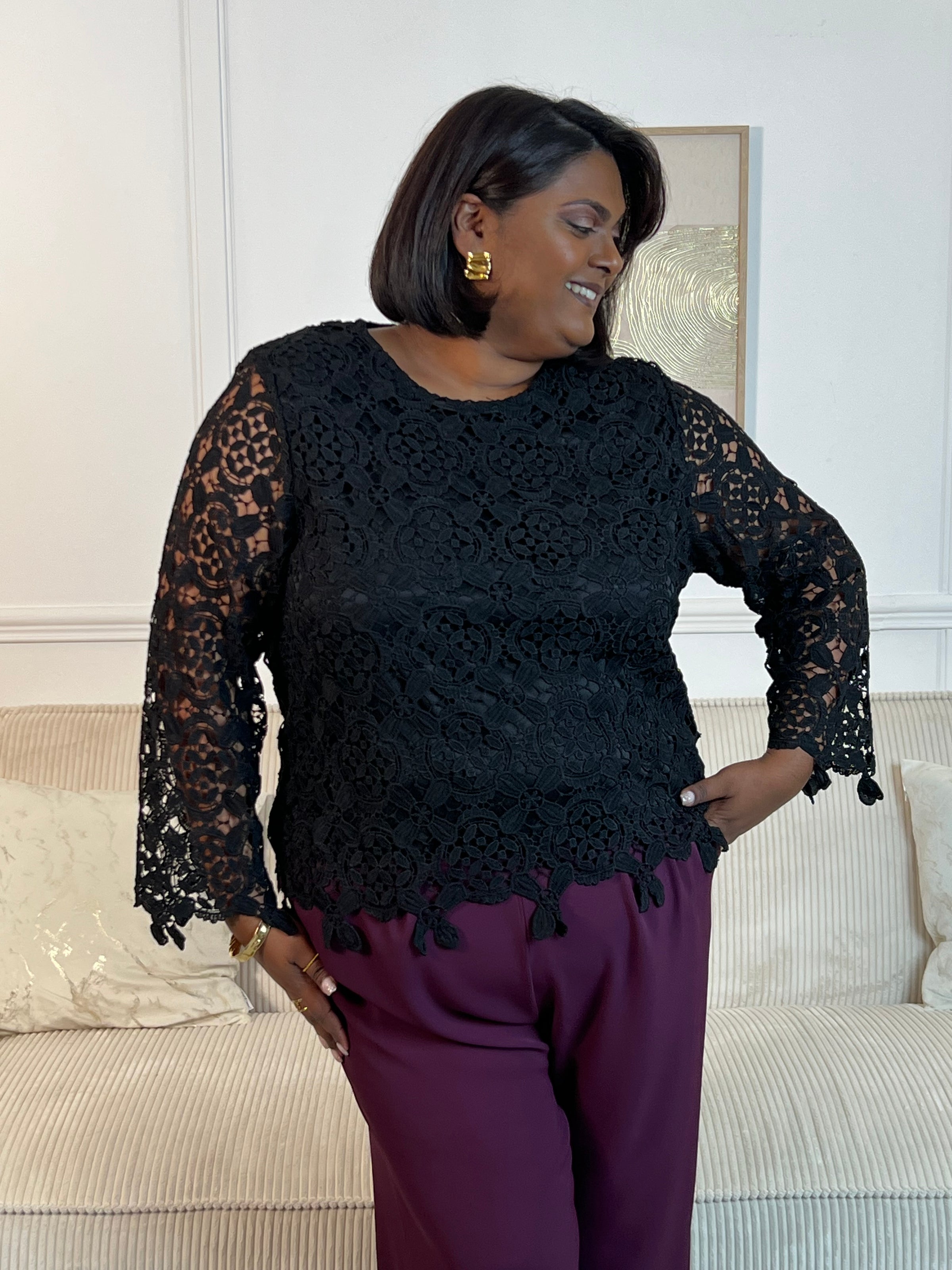 Cette blouse noire est ornée de broderies délicates, avec des manches longues en broderie et un col rond. Pratique avec ses boutons au dos et doublée à l'avant, elle ajoute une touche de délicatesse à votre garde-robe avec ses détails ajourés.