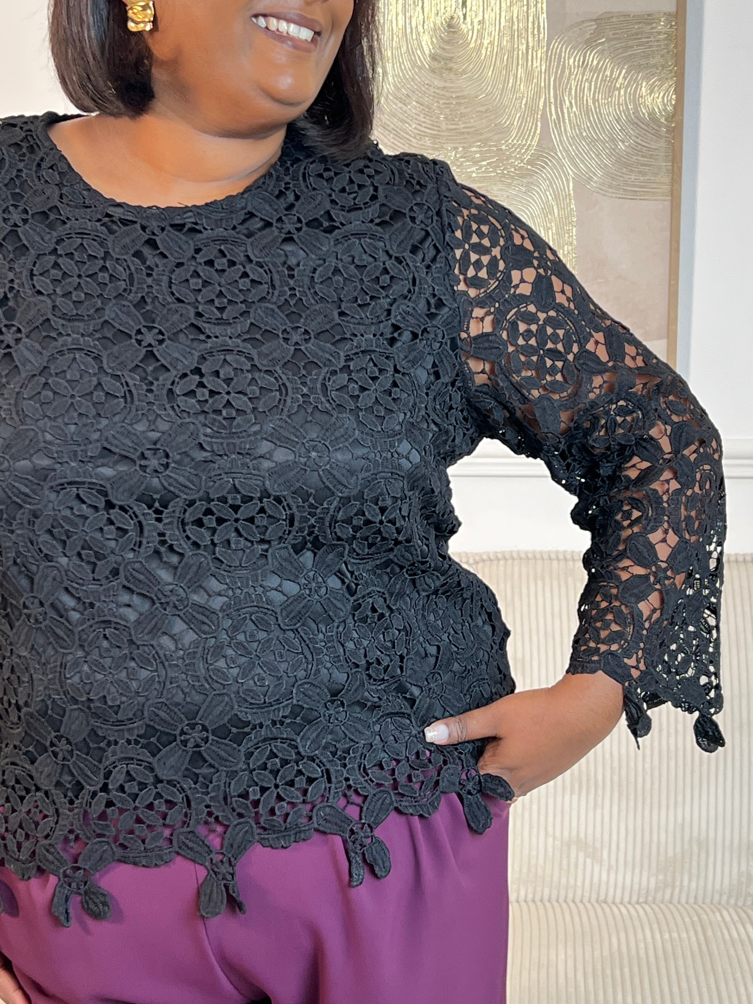 Cette blouse noire est ornée de broderies délicates, avec des manches longues en broderie et un col rond. Pratique avec ses boutons au dos et doublée à l'avant, elle ajoute une touche de délicatesse à votre garde-robe avec ses détails ajourés.