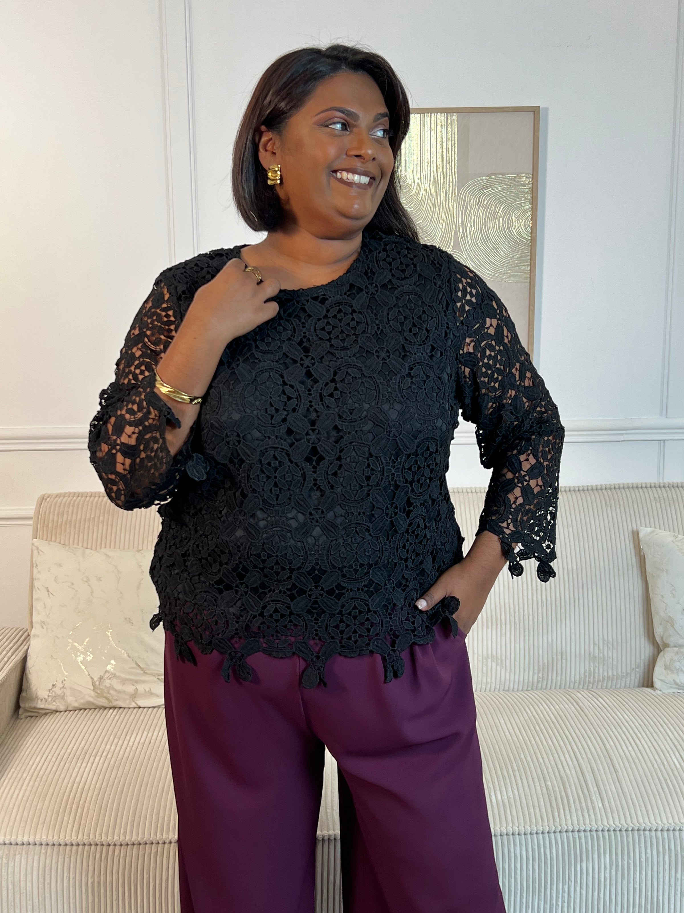 Cette blouse noire est ornée de broderies délicates, avec des manches longues en broderie et un col rond. Pratique avec ses boutons au dos et doublée à l'avant, elle ajoute une touche de délicatesse à votre garde-robe avec ses détails ajourés.