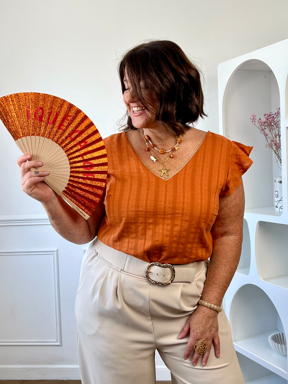 Blouse orange grande taille femme en coton, portée avec un pantalon beige pour un look estival et coloré.