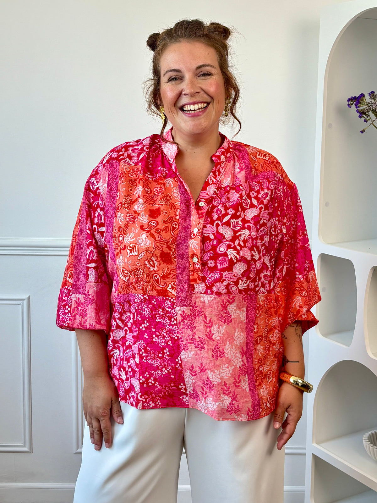 Blouse fluide grande taille femme portée avec un pantalon blanc pour un look coloré.