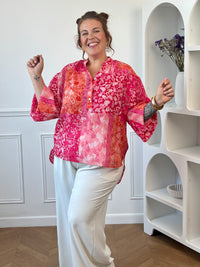 Blouse à motifs femme avec col V, manches longues et coupe ample légèrement transparente.