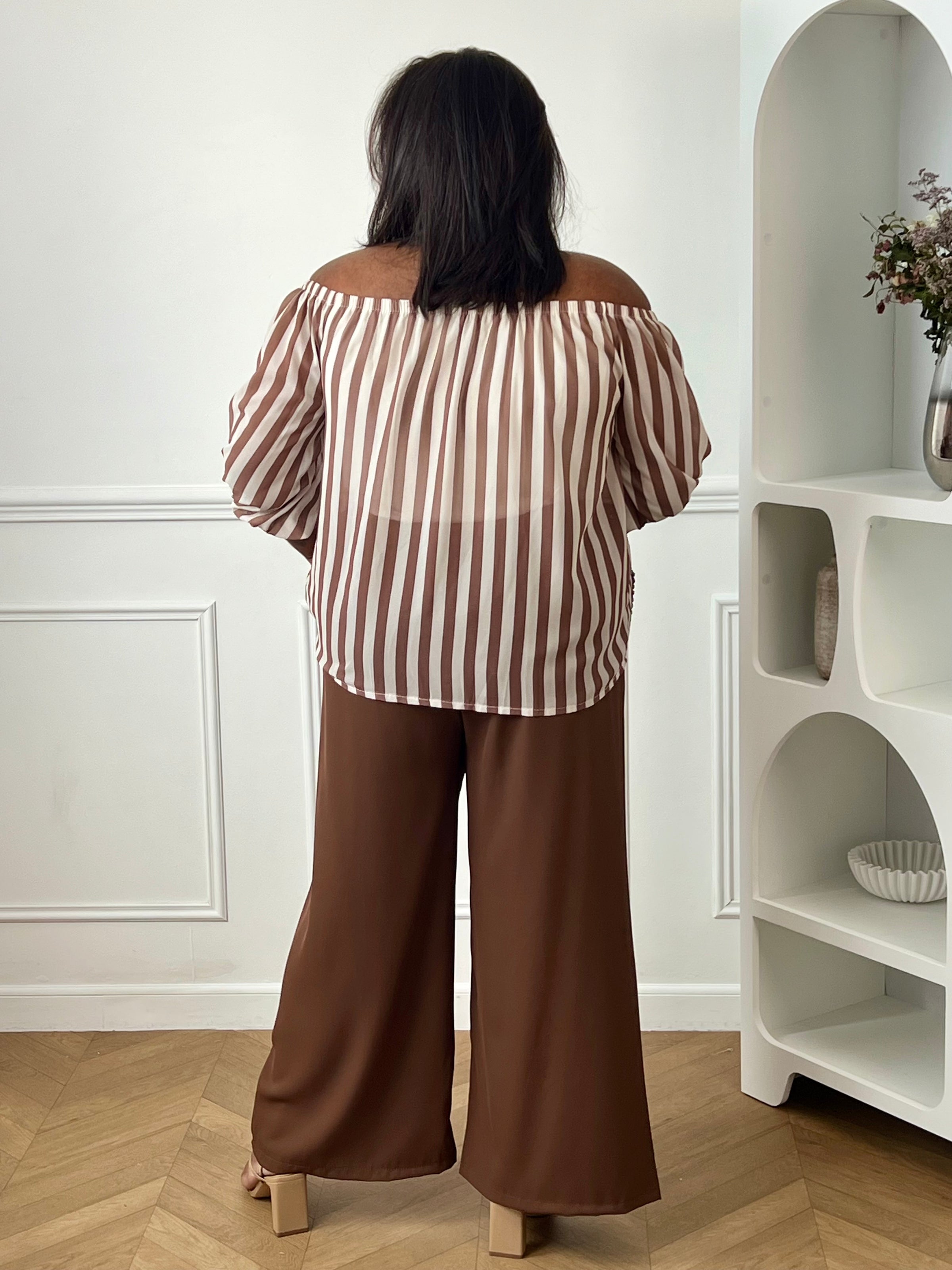 Adoptez un style élégant et confortable avec cette blouse grande taille à col bateau. Les rayures verticales taupe et écru allongent visuellement la silhouette, et le col bateau élastique ajoute une touche féminine et raffinée. Doublée sur le corps pour plus de confort, cette blouse est idéale pour un look chic au quotidien.