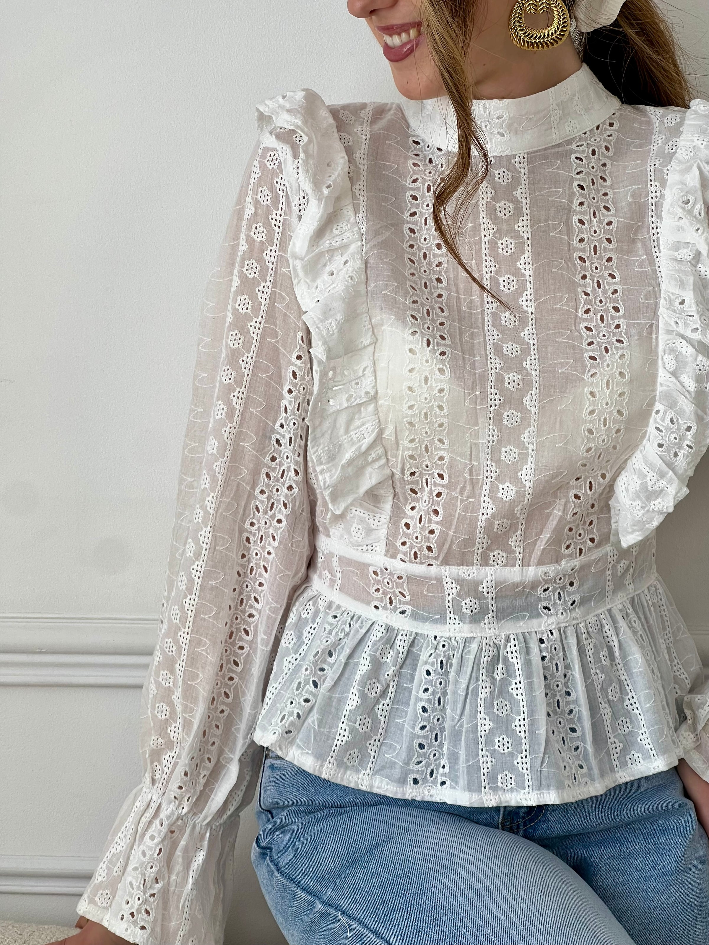 Blouse dos nu écrue femme, élégante et féminine, parfaite pour sublimer vos tenues. Dotée de manches longues, d’un col montant avec lien à nouer au dos et d’un joli dos nu, elle apporte une touche raffinée et tendance. Ses détails en broderie ajourée et ses volants ajoutent du charme, tandis que sa matière légèrement transparente offre légèreté et délicatesse. Élastiquée et boutonnée au bas du dos, cette blouse écrue allie confort et style pour un look chic.