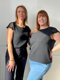 Apportez une touche d’élégance à votre dressing avec cette blouse noire en gaze de coton, légère et agréable à porter. Sa coupe sans manches met en valeur les épaules, sublimées par de délicats détails en dentelle au col et aux épaules. Son col rond à l’avant contraste subtilement avec son joli décolleté en V au dos, agrémenté de boutons factices pour une finition raffinée.