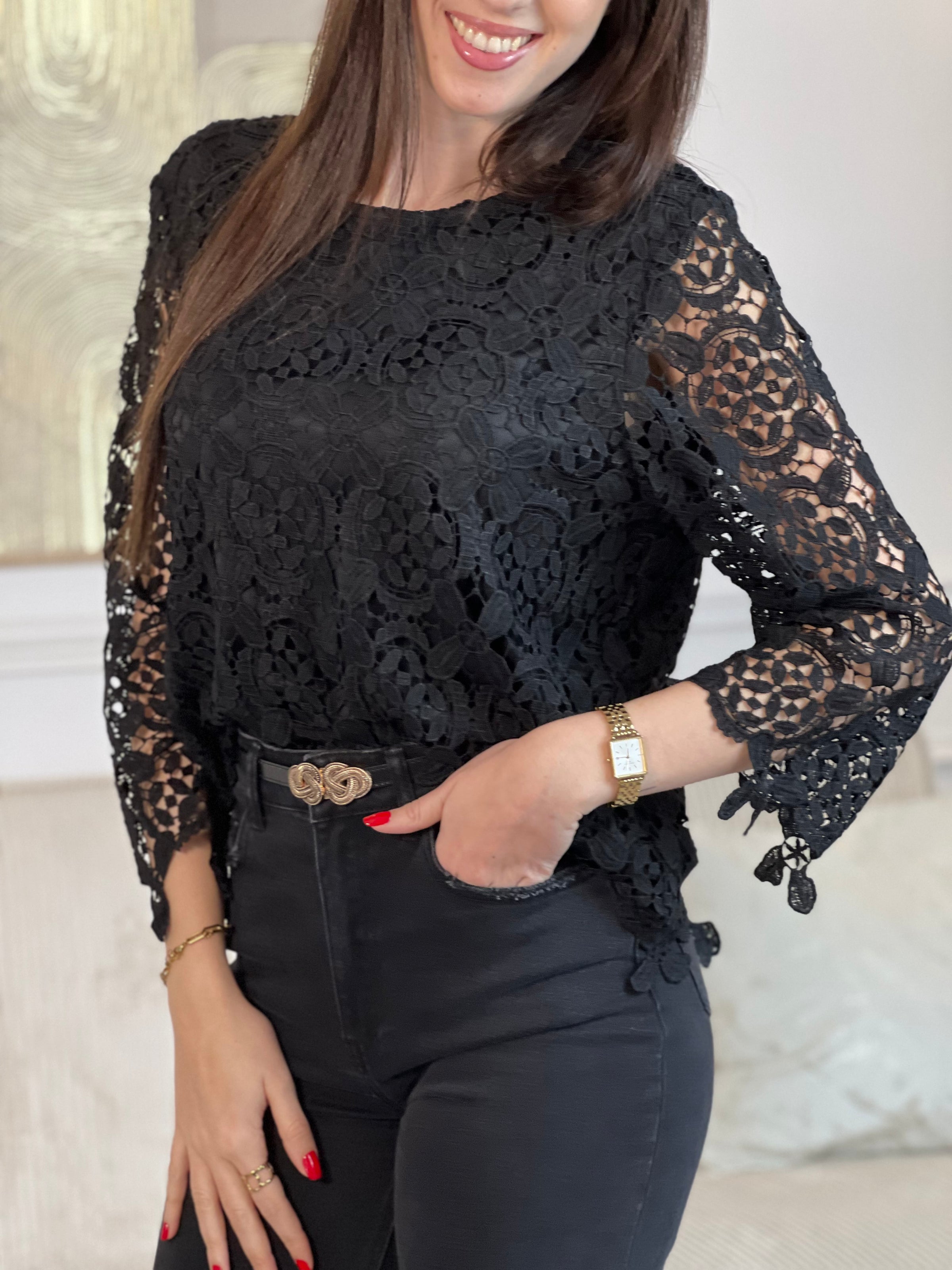 Cette blouse noire est ornée de broderies délicates, avec des manches longues en broderie et un col rond. Pratique avec ses boutons au dos et doublée à l'avant, elle ajoute une touche de délicatesse à votre garde-robe avec ses détails ajourés.