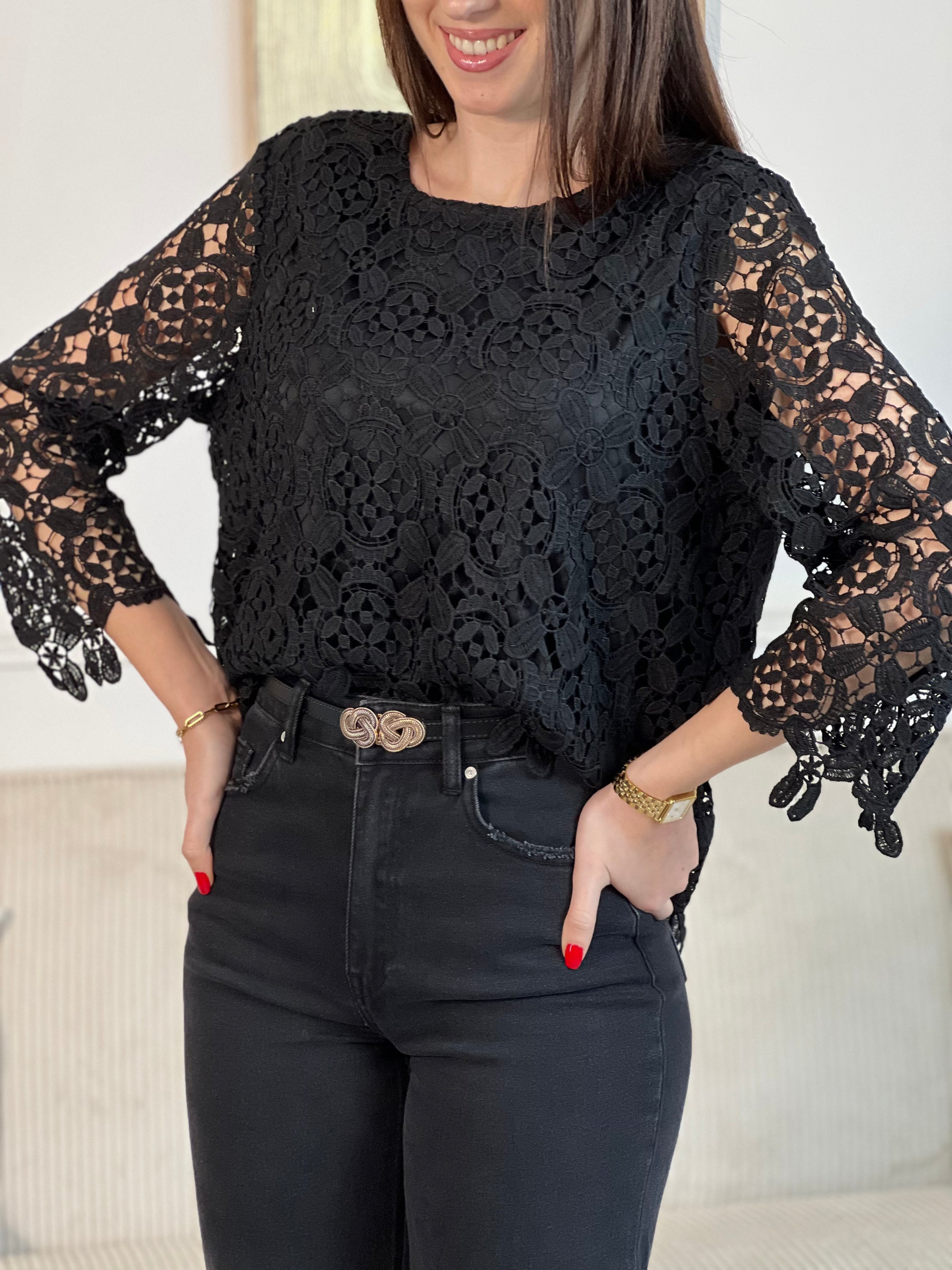 Cette blouse noire est ornée de broderies délicates, avec des manches longues en broderie et un col rond. Pratique avec ses boutons au dos et doublée à l'avant, elle ajoute une touche de délicatesse à votre garde-robe avec ses détails ajourés.