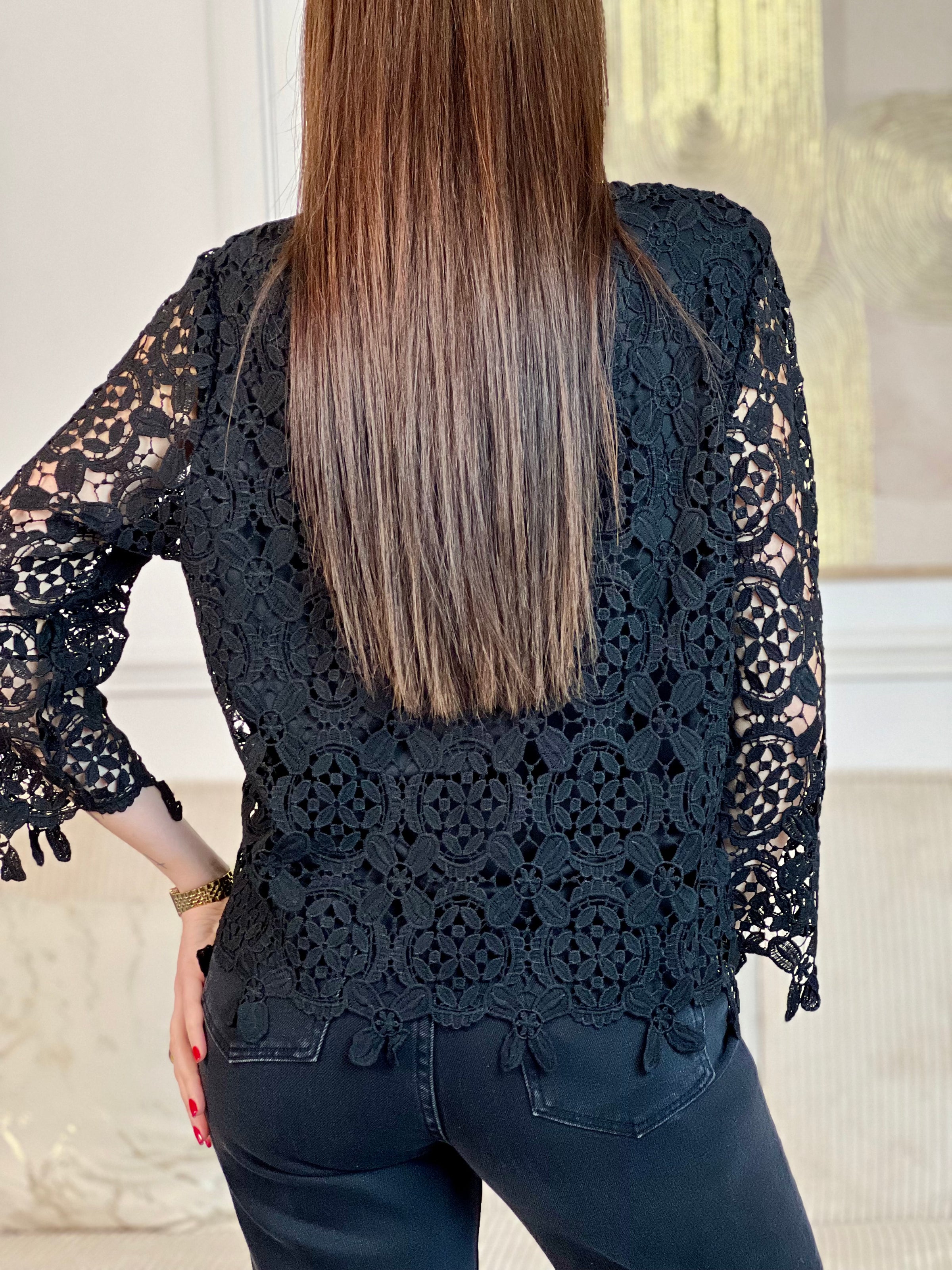 Cette blouse noire est ornée de broderies délicates, avec des manches longues en broderie et un col rond. Pratique avec ses boutons au dos et doublée à l'avant, elle ajoute une touche de délicatesse à votre garde-robe avec ses détails ajourés.