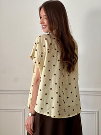 Cette blouse ample jaune illumine votre tenue avec sa couleur éclatante. Ses pois marron apportent une touche rétro et tendance, tandis que sa coupe fluide assure confort et légèreté. Une pièce facile à porter pour un look frais et stylé.