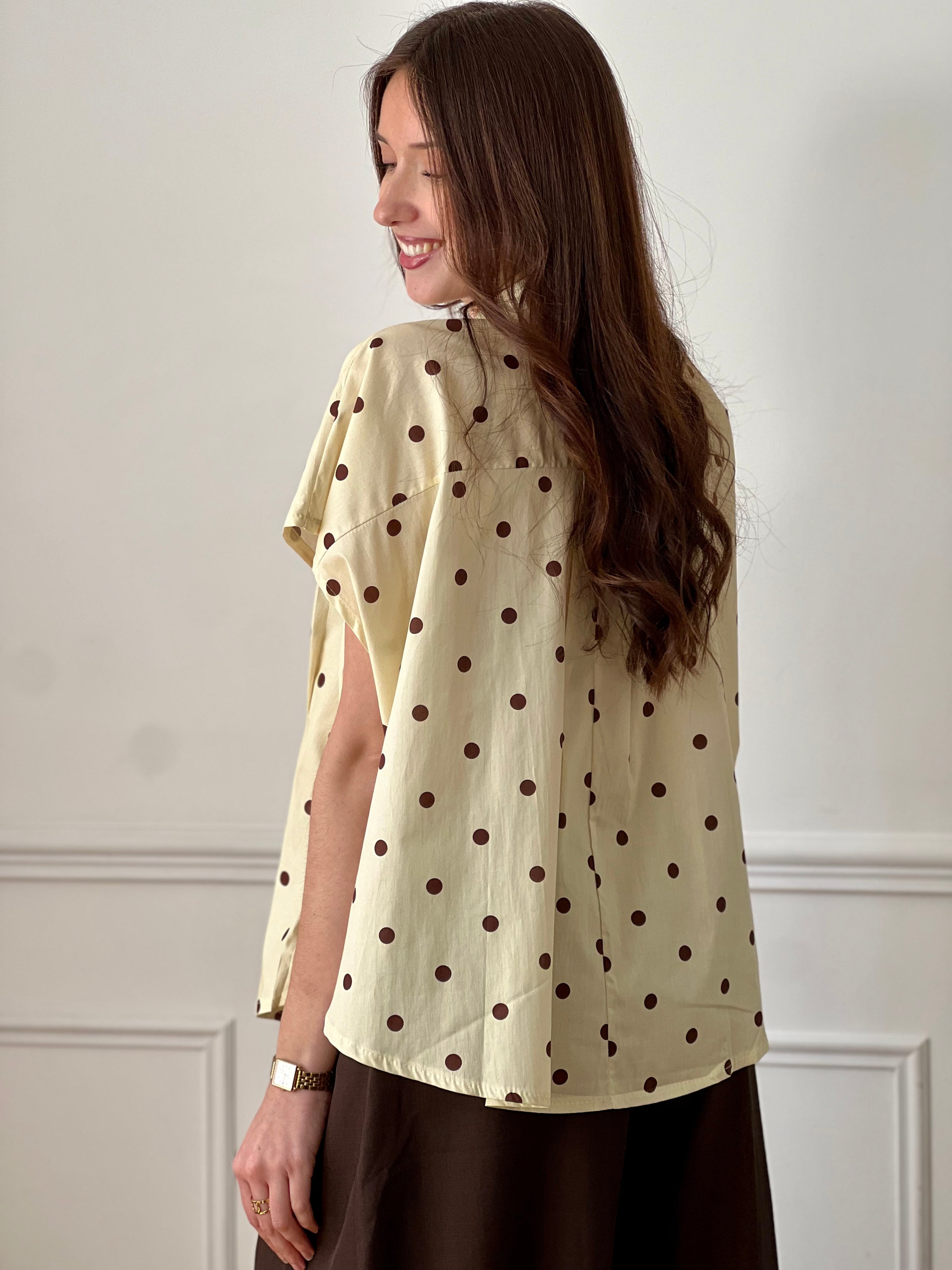 Cette blouse ample jaune illumine votre tenue avec sa couleur éclatante. Ses pois marron apportent une touche rétro et tendance, tandis que sa coupe fluide assure confort et légèreté. Une pièce facile à porter pour un look frais et stylé.