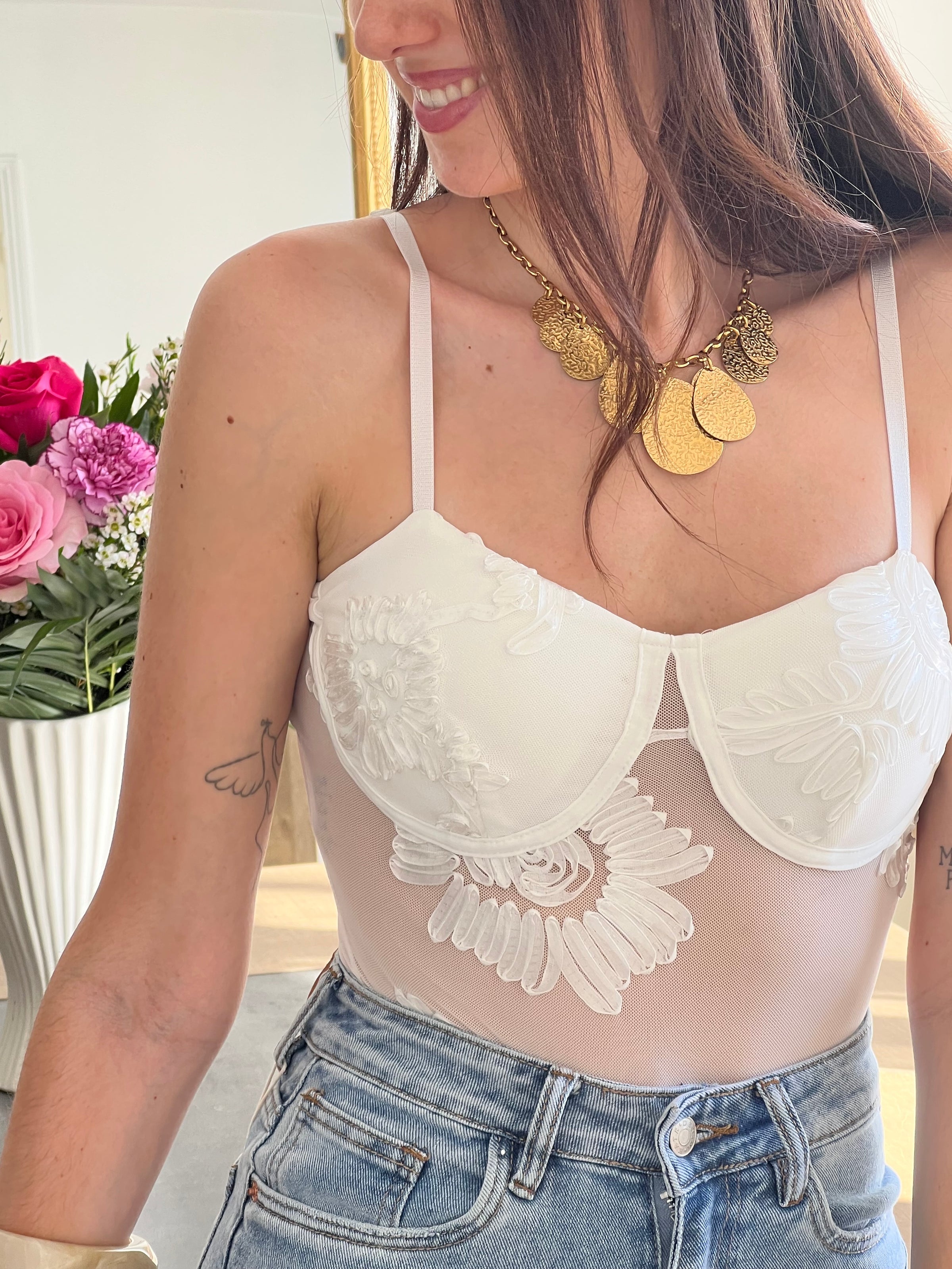 Craquez pour ce body blanc femme, à la fois séduisant et confortable. Doté de bretelles réglables et d’un soutien-gorge sans armature, il assure un maintien tout en douceur. Sa matière transparente sublimée par des motifs brodés apporte une touche raffinée, tandis que son attache à crochets garantit un ajustement parfait. Un modèle élégant et féminin.