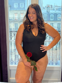 Body noir grande taille conçu pour sublimer votre silhouette avec élégance. Coupe sans manches et col V qui affine la ligne, agrémentée de légers plis latéraux pour un confort optimal. Fermeture par attache crochets pratique et discrète. Pièce incontournable en noir pur, parfaite pour créer des looks épurés et intemporels.