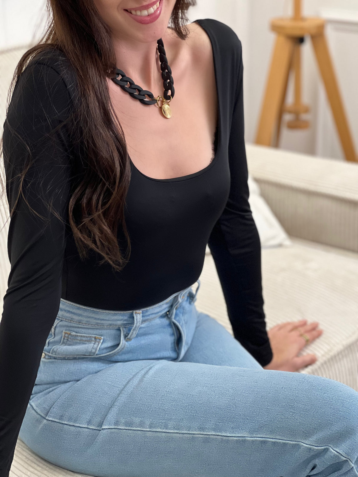 Body noir élégant aux manches longues et col carré. Fermeture pratique avec accroche crochet pour un ajustement sur mesure. Un incontournable polyvalent à porter seul ou en superposition.